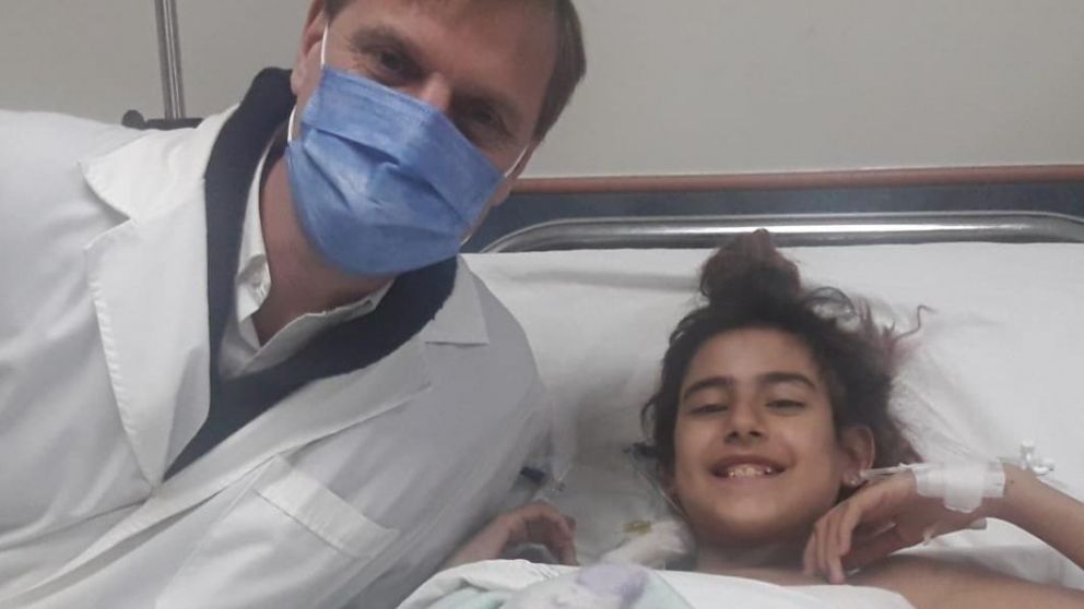 Lucila, de 13 años, junto al médico que la asistió en su trasplante de riñón.