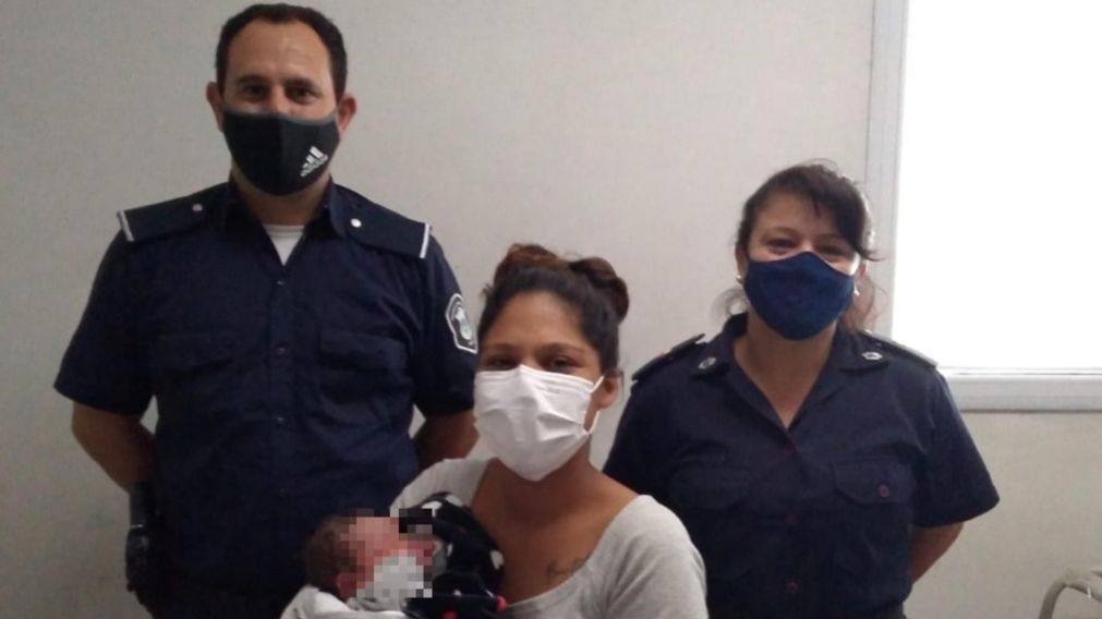 La madre, la niña y dos de los uniformados que ayudaron en el parto.