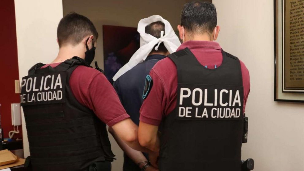 La Policía se lleva a uno de los detenidos en el consultorio de Palermo.