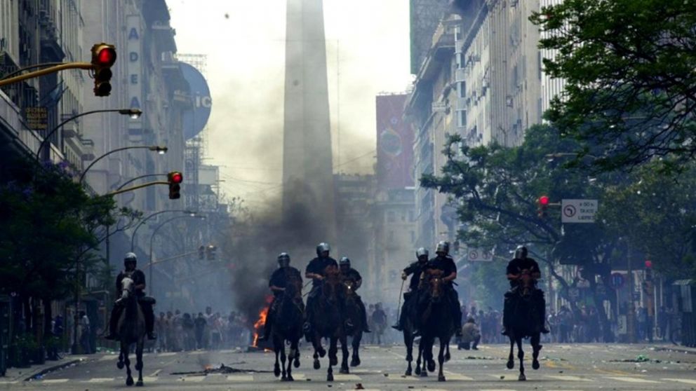 Una imagen icónica de aquellas jornadas aciagas: la Montada en plena tarea represiva y el Obelisco tiznado por el humo y los gases.
