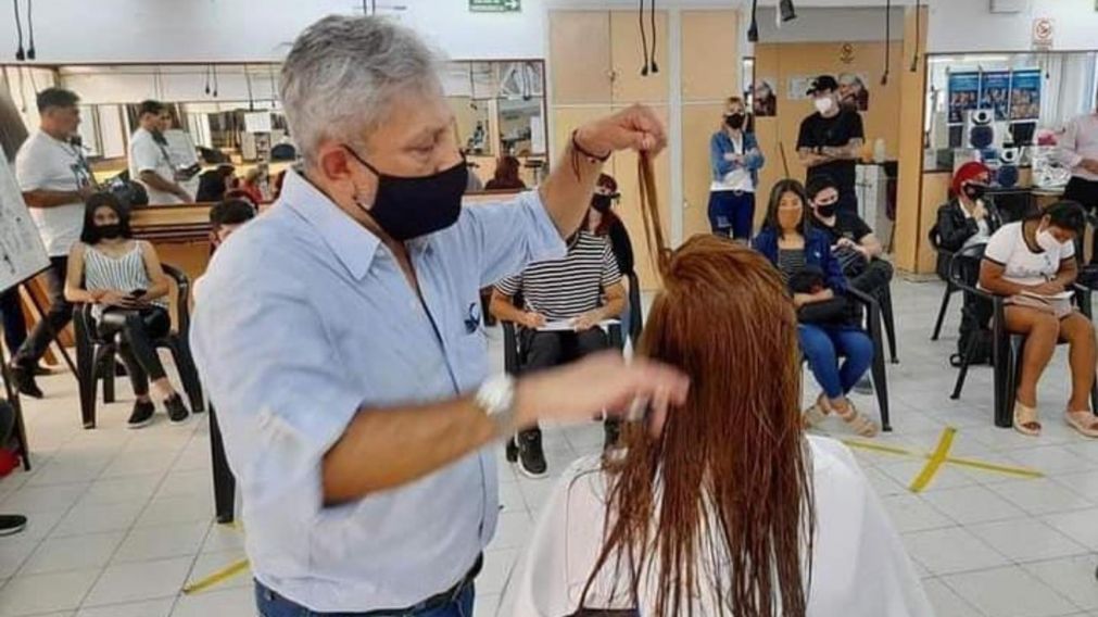 Félix Gauna peina a su clienta frente a un grupo de estudiantes.