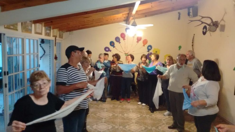 Los adultos mayores bailan alegres entre amigos.