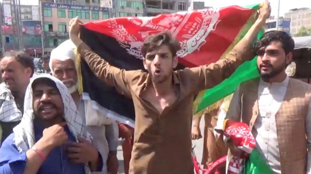 Manifestantes muestran la tradicional bandera afgana en se�al de protesta contra los talibanes (Afghan news).