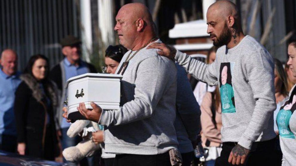 El padre del bebé cargando el ataúd en el funeral de su hijo.