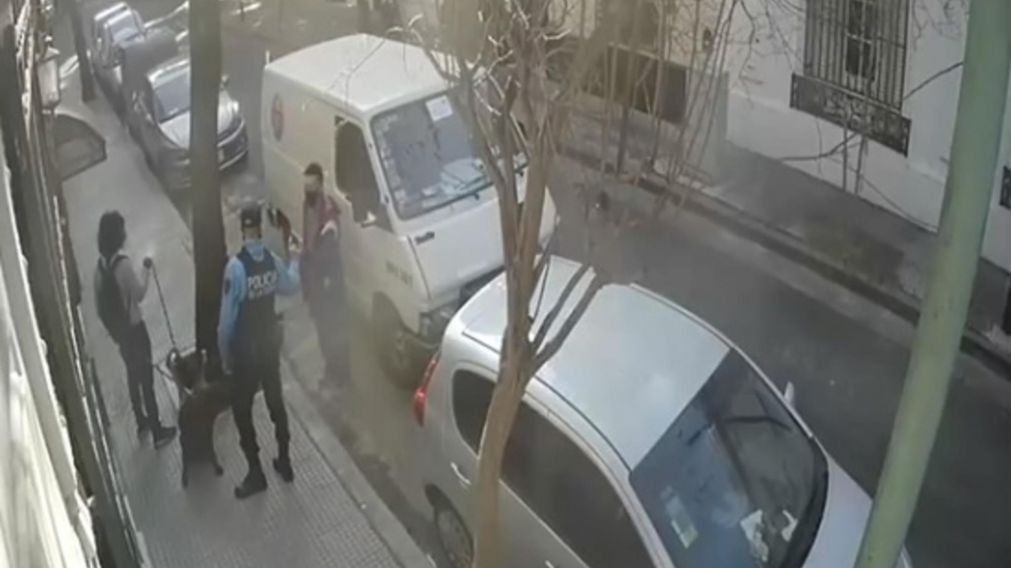 El momento en que el agente le devuelve la billetera al sodero, ante la mirada del paseador de perros (Captura de pantalla).
