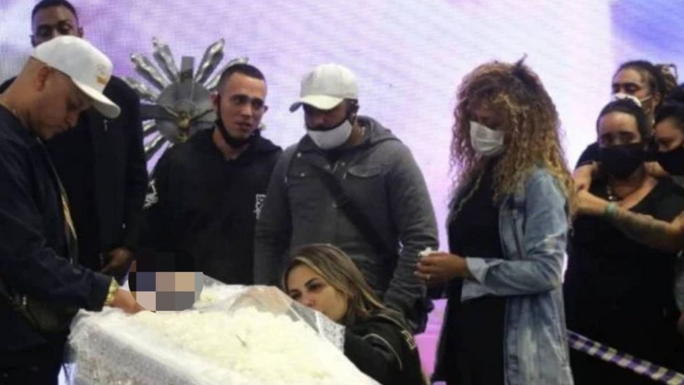 Deolane Bezerra desconsolada apoyada en el féretro de MC Kevin.