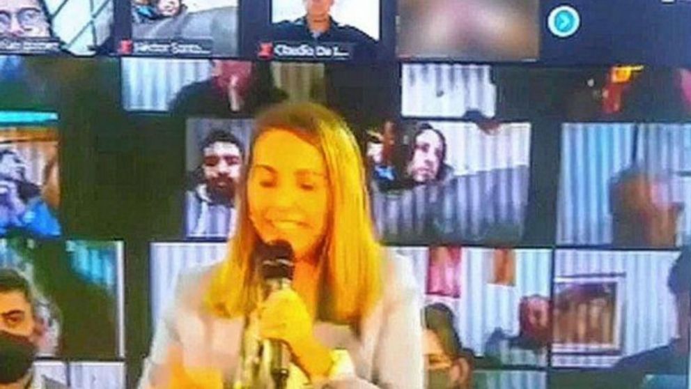 La vicegobernadora Laura Stratta hablando mientras atrás aparecen jóvenes "haciendo el amor".
