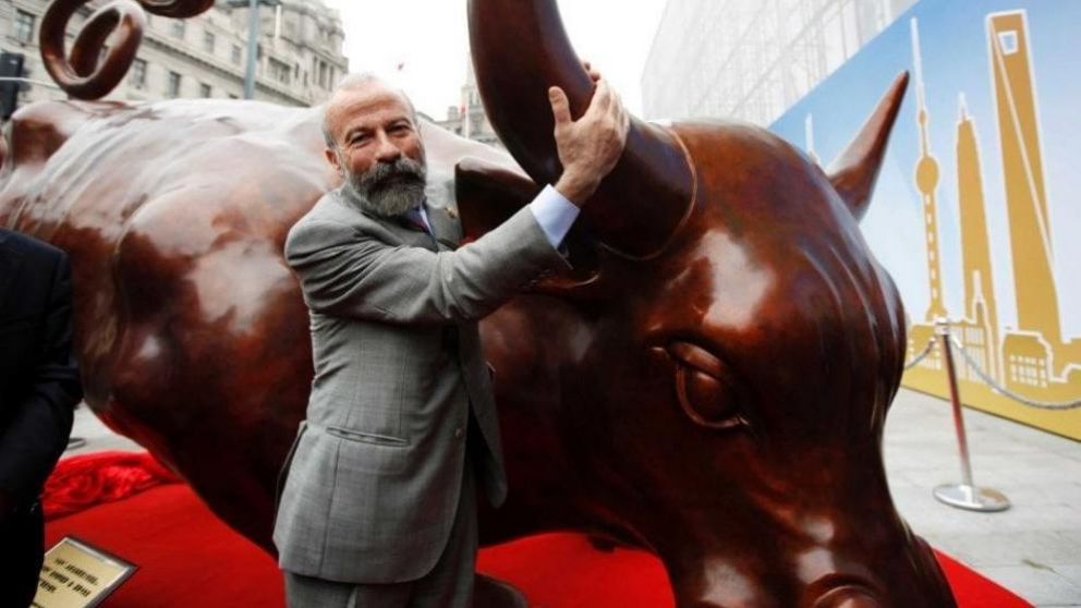 Arturo Di Modica, junto a su escultura, el "Charging Bull".