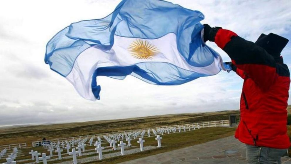 Un argentino con la enseña patria en el cementerio de Darwin.