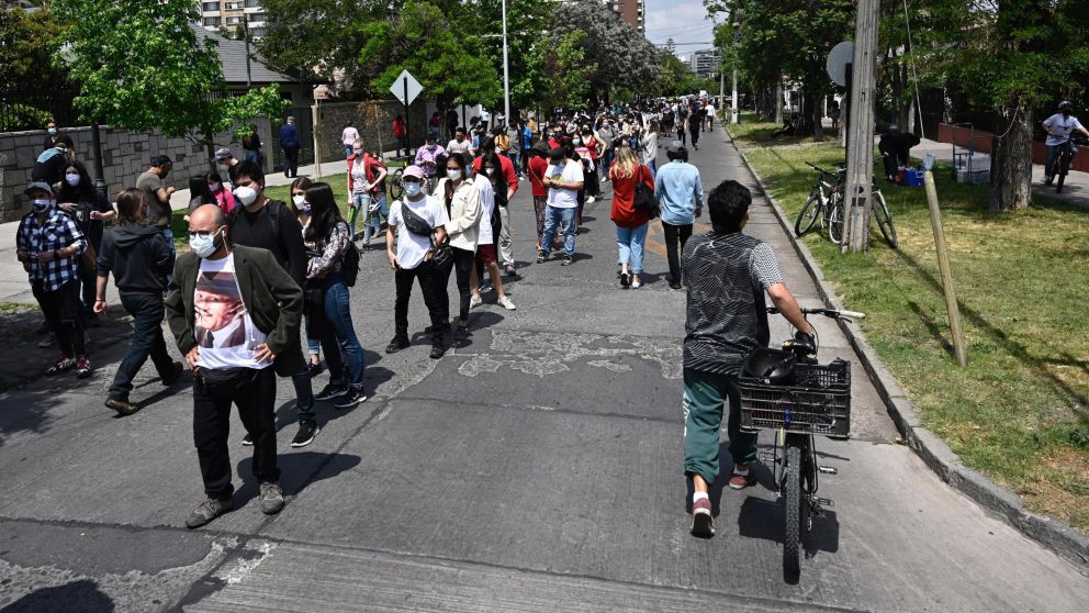 Largas filas y estrictas medidas sanitarias marcan el histórico plebiscito chileno.