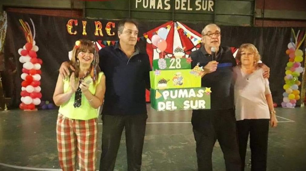 En una reunión previa a la pandemia, Flores habla junto a su esposa y sus compañeros.