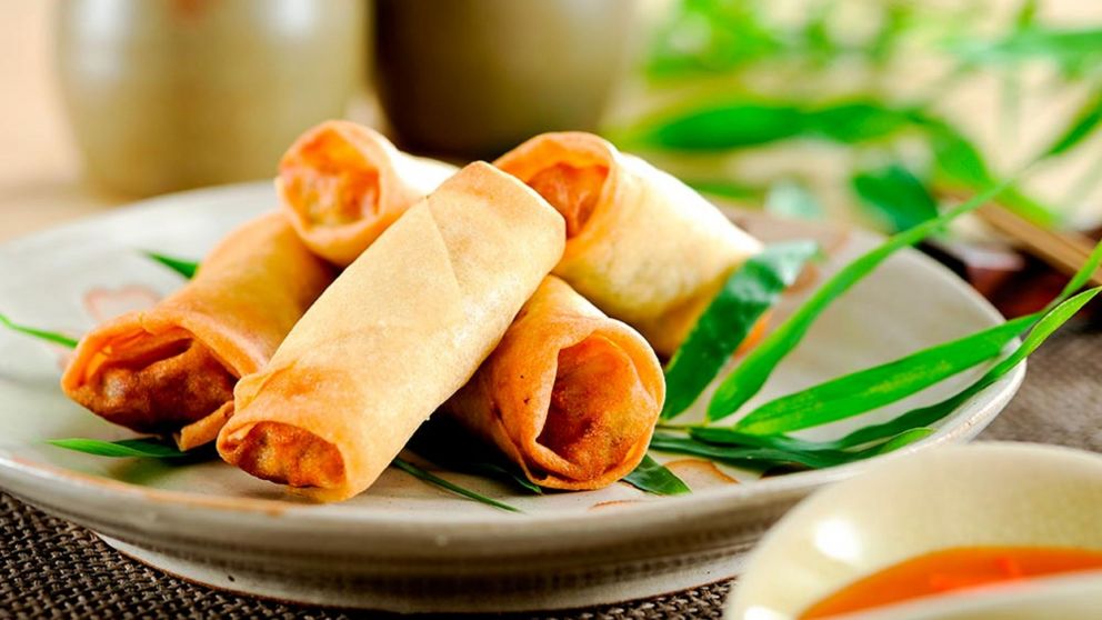 Rollitos recién hechos, dorados y crujientes, listos para acompañar con salsa agridulce o de soja.