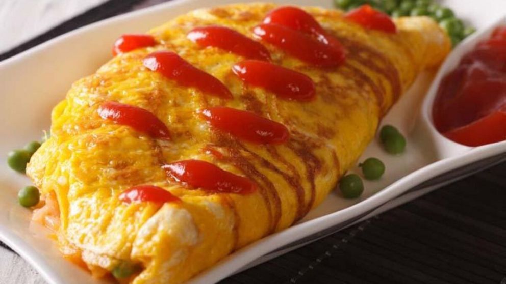 Omurice servido al estilo tradicional japon�s, con su caracter�stico manto de huevo esponjoso sobre arroz salteado.