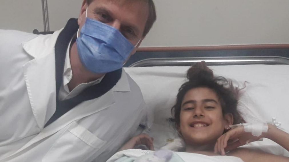 Lucila, de 13 años, junto al médico que la asistió en su trasplante de riñón.
