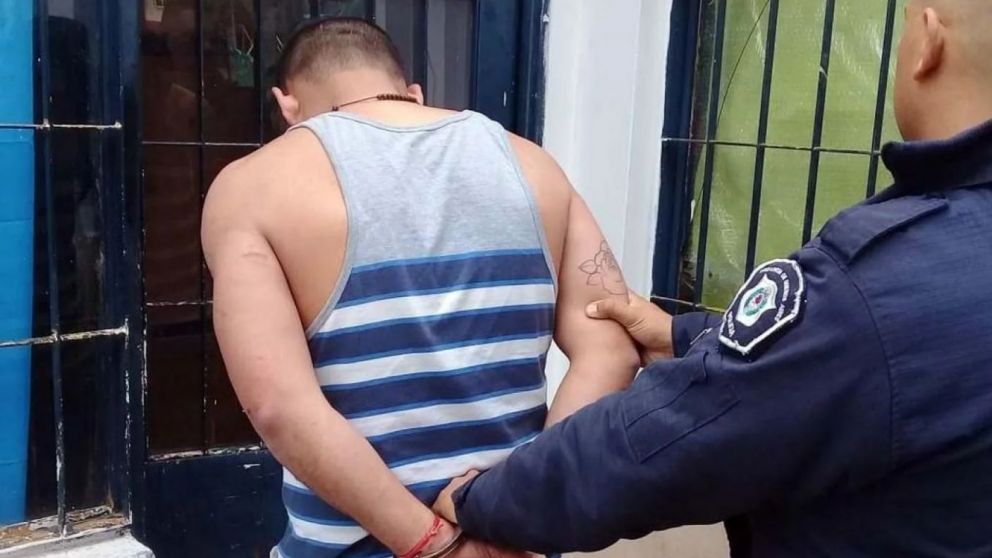 El hombre siendo detenido por fuerzas de seguridad.