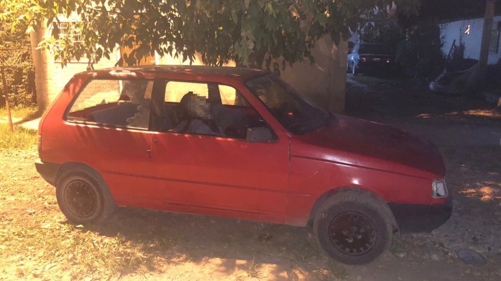 El cad�ver acuchillado de uno de los j�venes yace en el habit�culo del Fiat Uno rojo.
