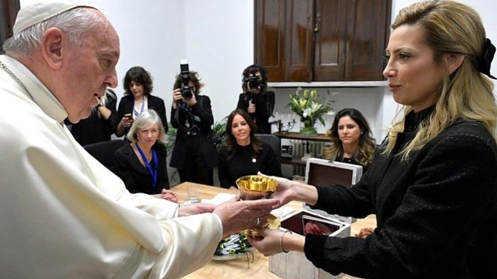 La primera dama Fabiola Yañez le entrega el cáliz al papa.