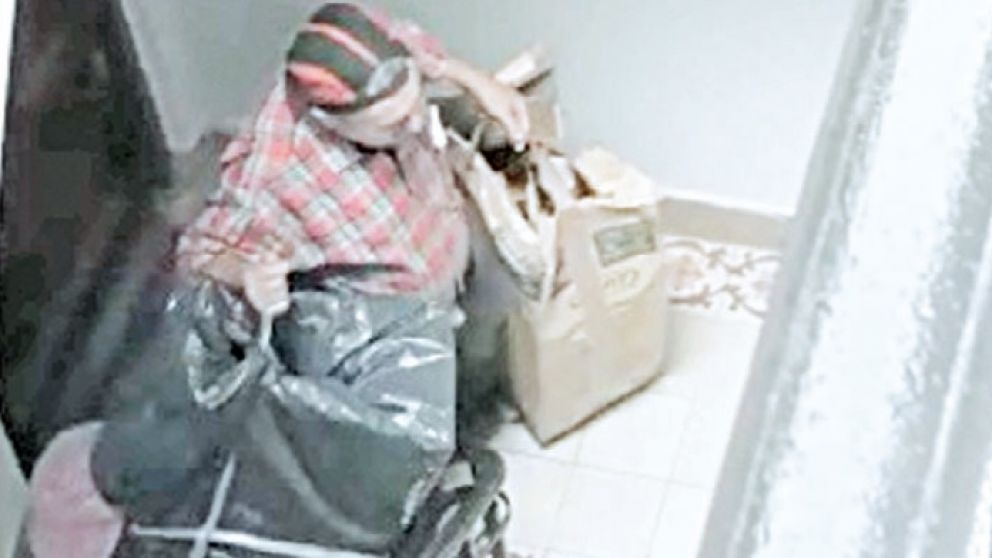 Una imagen del hombre ingresando basura a su vivienda.