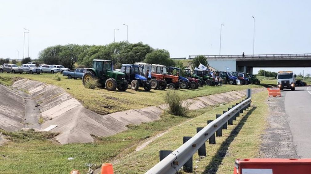 Tractores y otros vehículos, estacionados a la vera de la autopista Córdoba-Rosario.