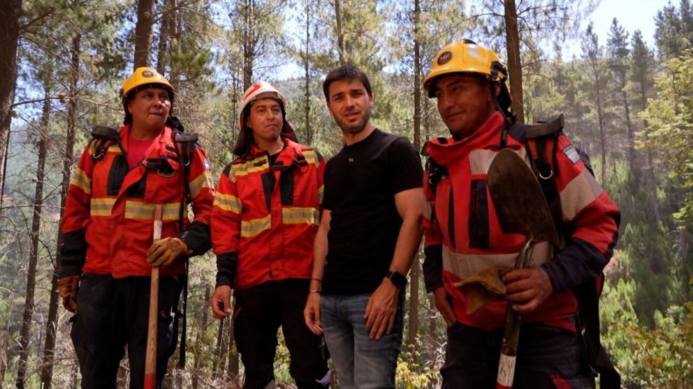 El gobernador Ignacio Torres, junto a un grupo de bomberos que trabaja para combatir las llamas.