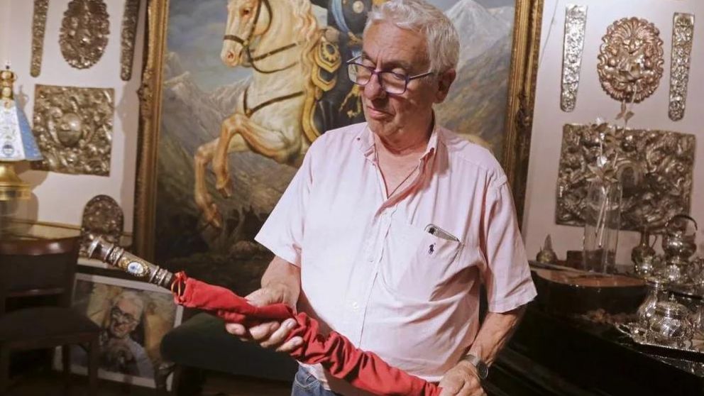 El artista Juan Carlos Pallarols sosteniendo el emblema patrio.