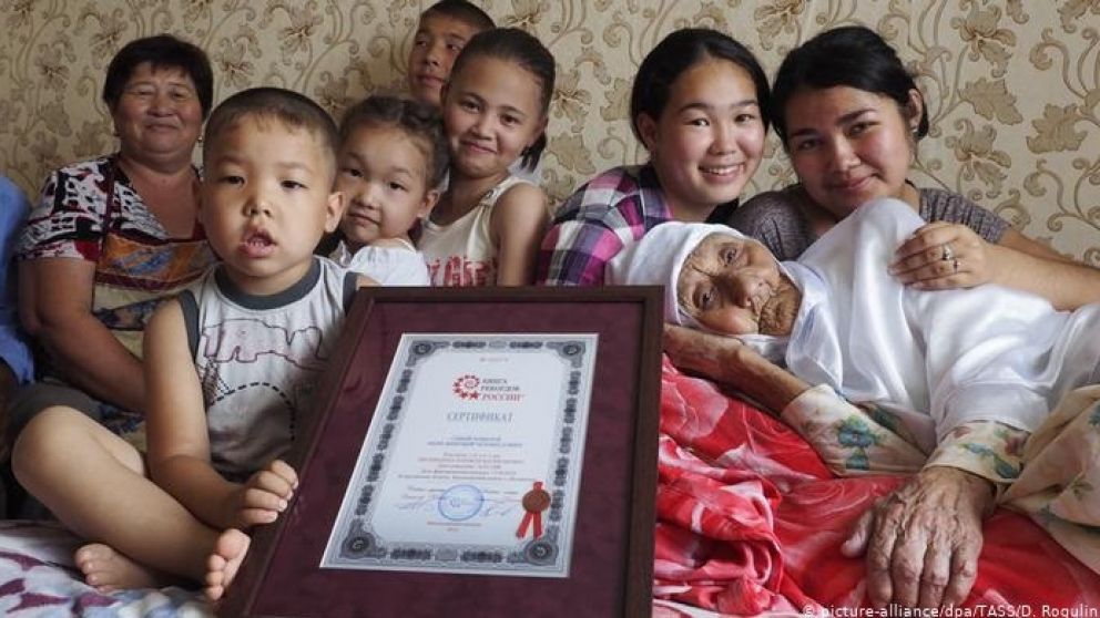 Bisembeyeva, junto a su familia y el certificado que la nombra como la mujer más longeva de Rusia.