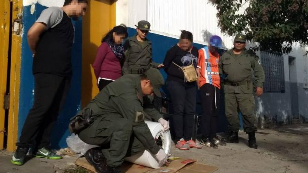 La pareja viendo como un gendarme saca la droga en el termotanque.
