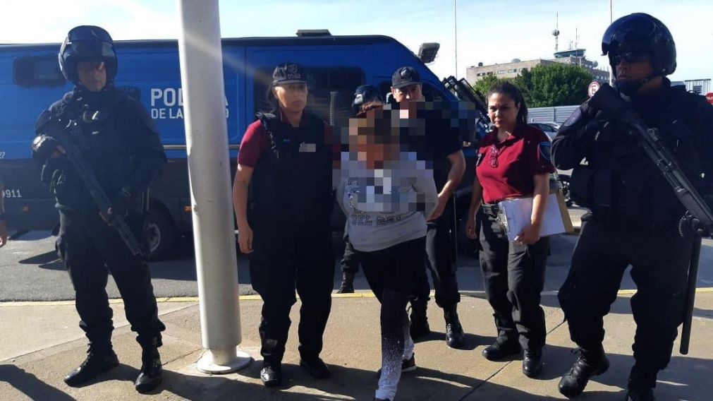 La policía y personal de Migraciones trasladando a la mujer deportada. (@NPolicialesBA)