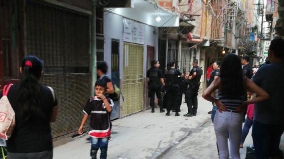 La policía, en la puerta de la casa donde aparecieron los cadáveres.