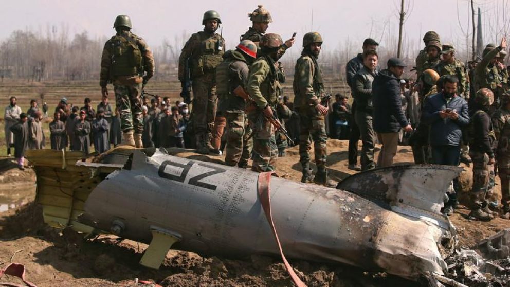 Las tropas indias desfilan junto a restos de un aeronave. (Reuters).