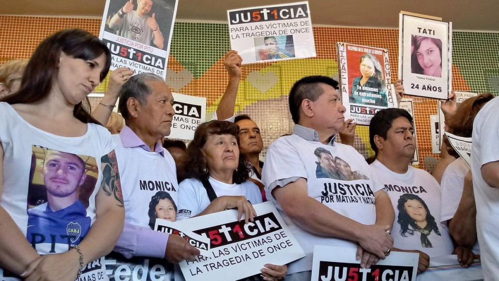 Familiares con las fotos de sus seres queridos en el homenaje.