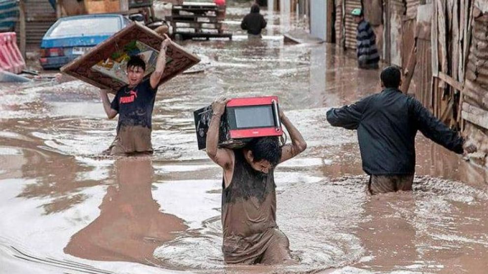 Las personas tratan de sacar objetos de sus hogares y llevarlos a una zona segura.