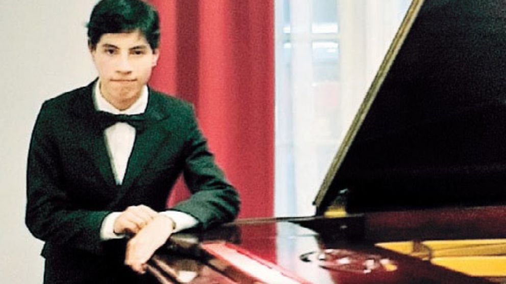 El talentoso joven posa junto a un piano.