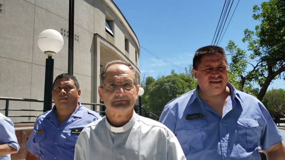 El cura Carlos Scarlata, acompañada por efectivos policiales.