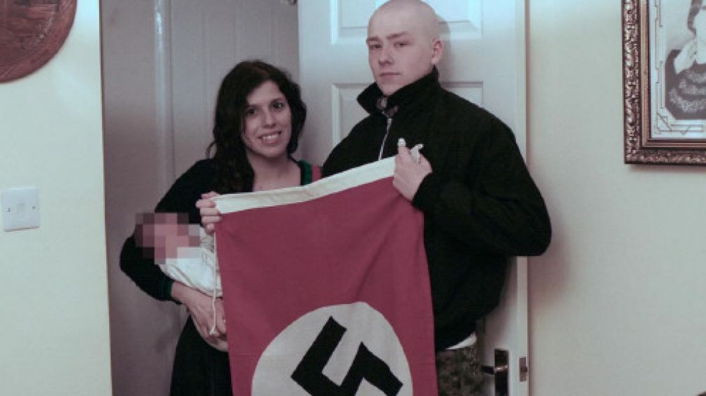 Claudia Patatas y Adam Thomas, junto a su pequeño y una bandera nazi.