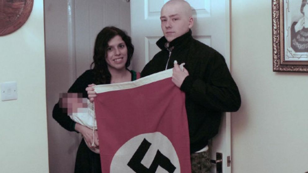 Claudia Patatas y Adam Thomas, junto a su pequeño y una bandera nazi.