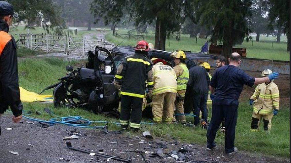 Bomberos y personal de rescate trabajan en uno de los vehículos del fatal accidente.