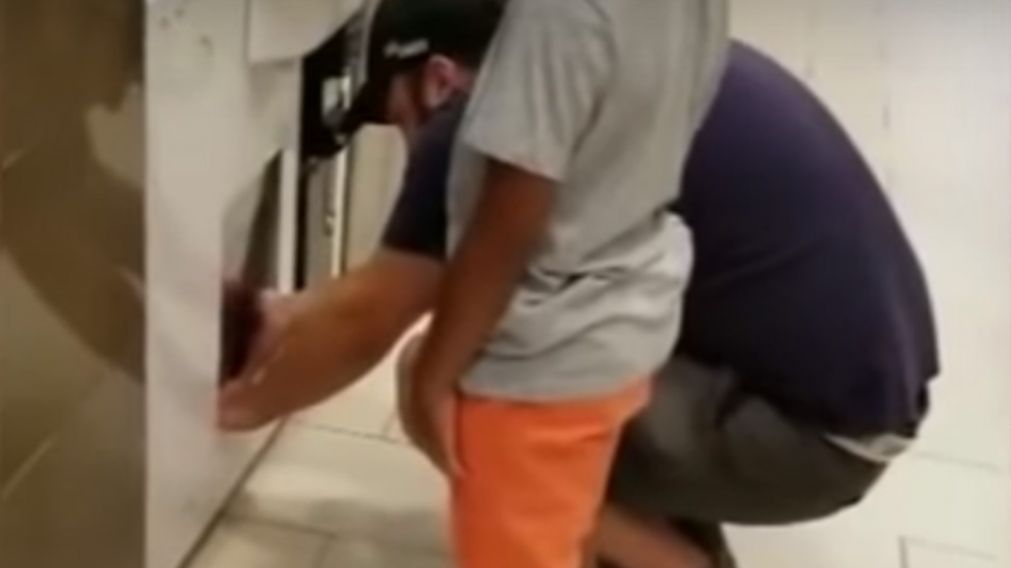 Así el padre retiraba los objetos que le daba su hija desde adentro de la maquina. (Captura de video)