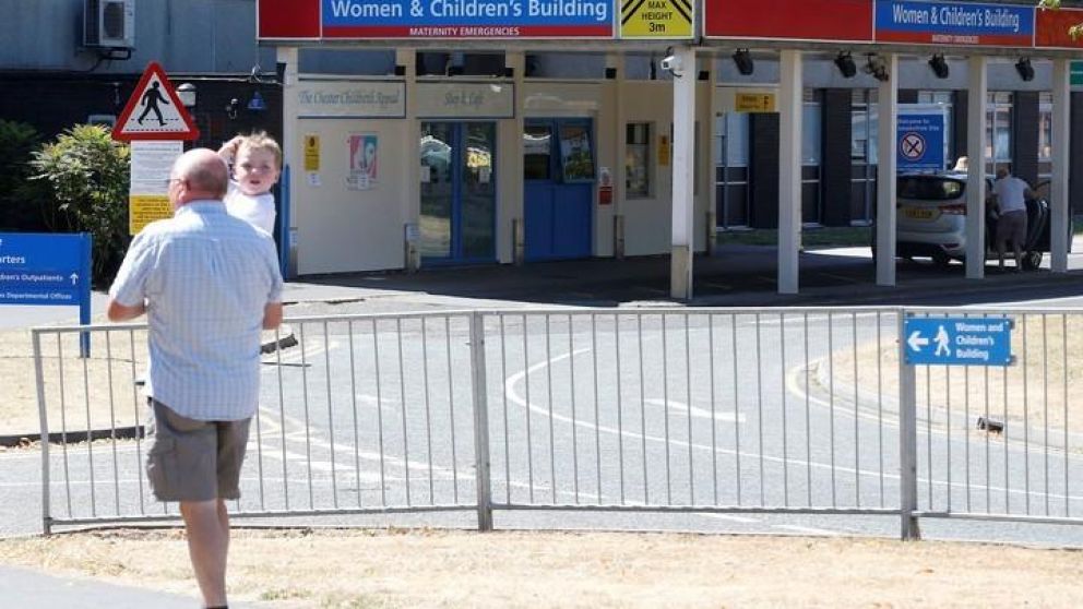 Un hombre, llevando a un nenito al nosocomio británico (Reuters).