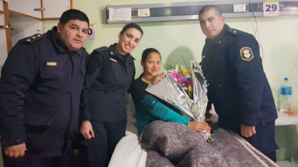 Tres de los policías que actuaron en los partos visitan a una de la madres.