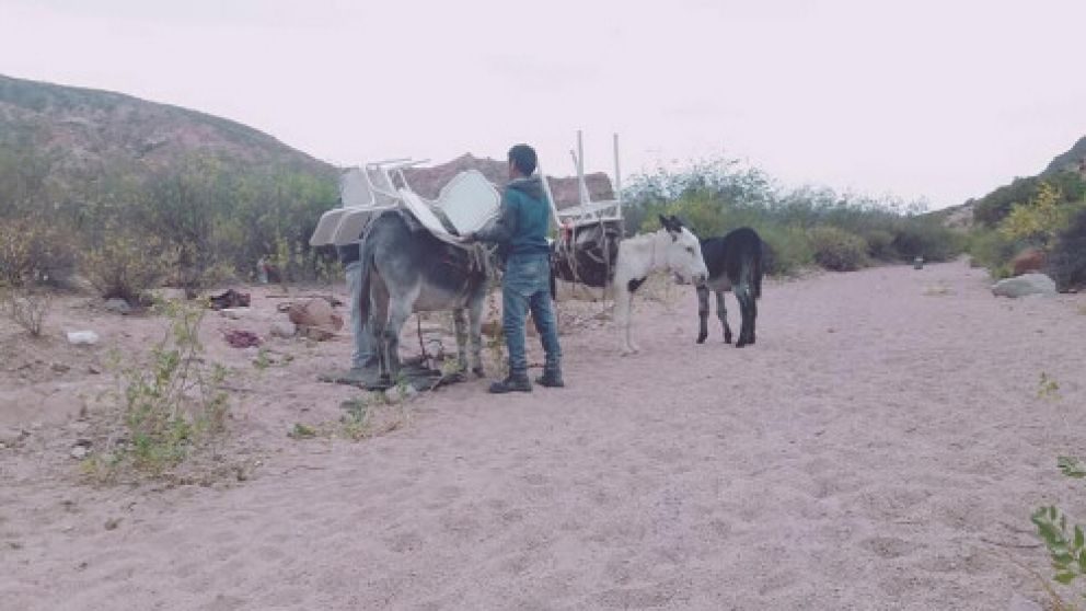 Uno de los papás, transportando sillas hacia la escuelita (gentileza elesquiu.com).
