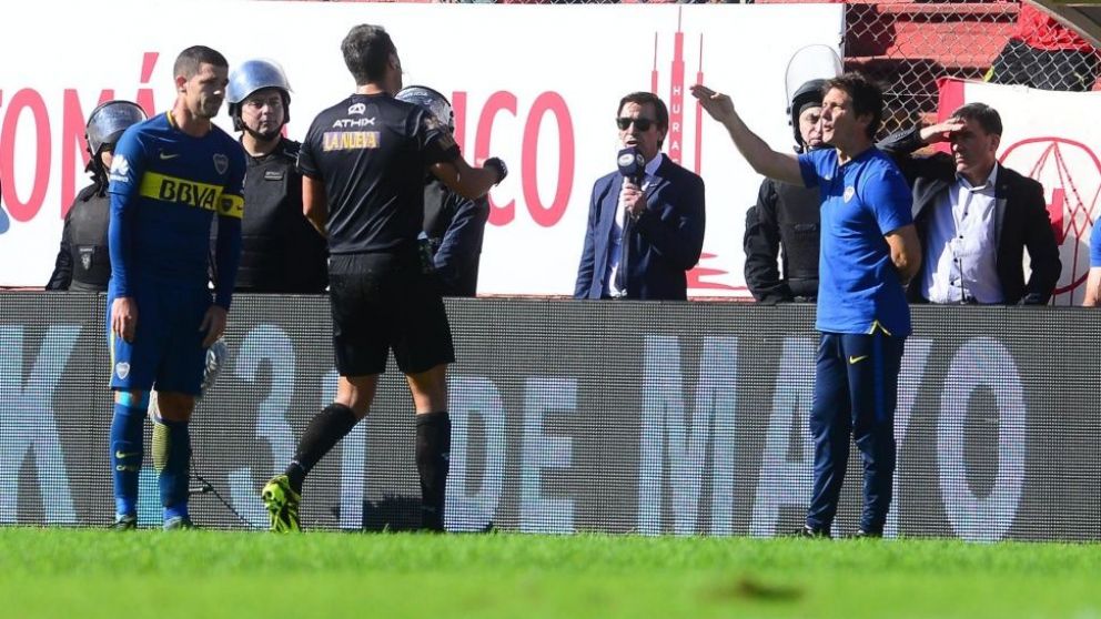 Un incómodo momento entre el 5 de Boca, el referi y el Mellizo.
