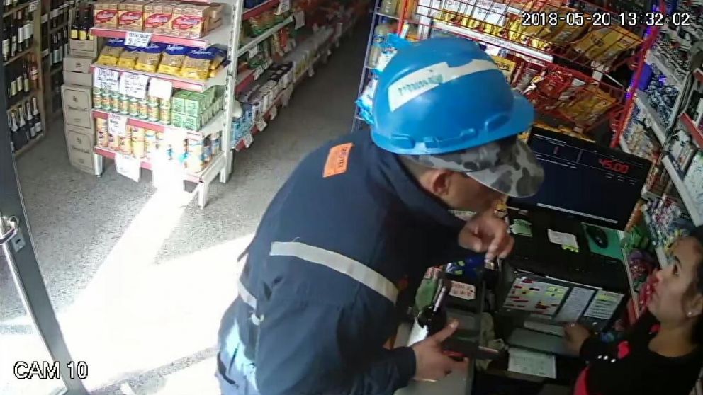 El momento en que el delincuente le pide silencio a la cajera.