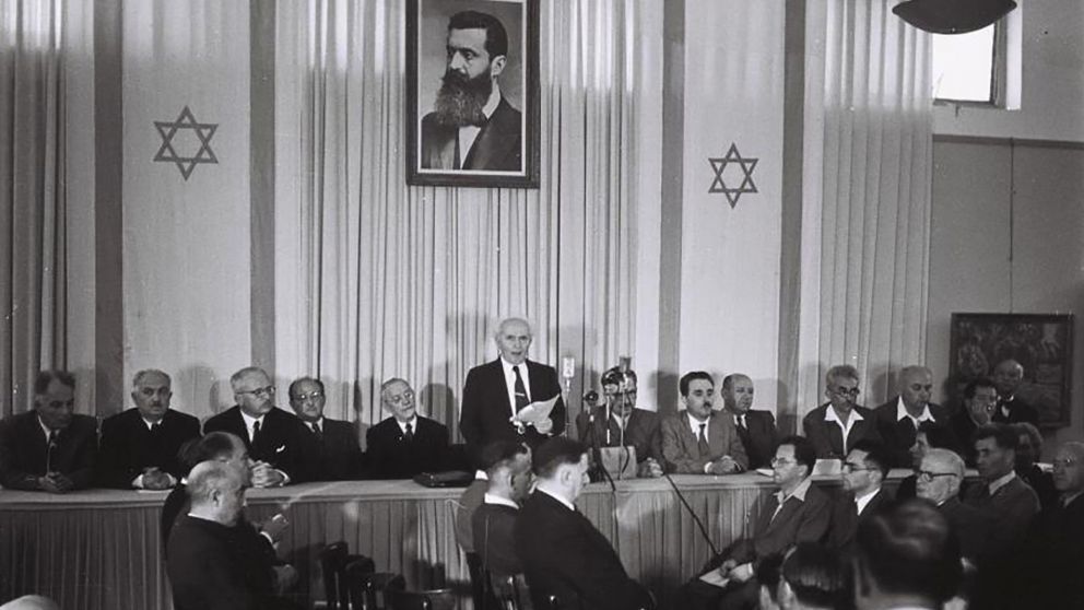 Ben-Gurión lee el acta de independencia, bajo el retrato de Herzl.