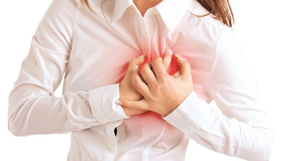 Woman having a pain in the heart area, isolated in white, red circle around painful area