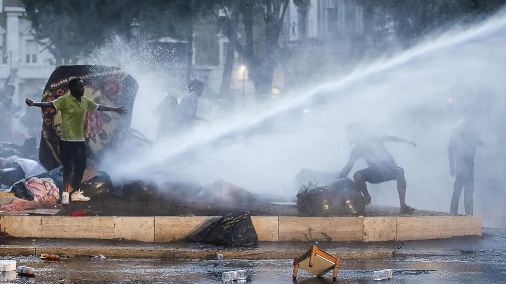 Camiones hidrantes contra refugiados que acampaban en una plaza.
