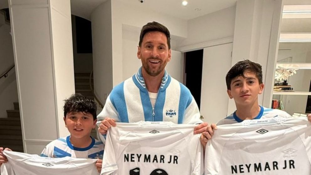 Lionel y dos de su hijos posa con las camisetas de Santos que les regaló Neymar.