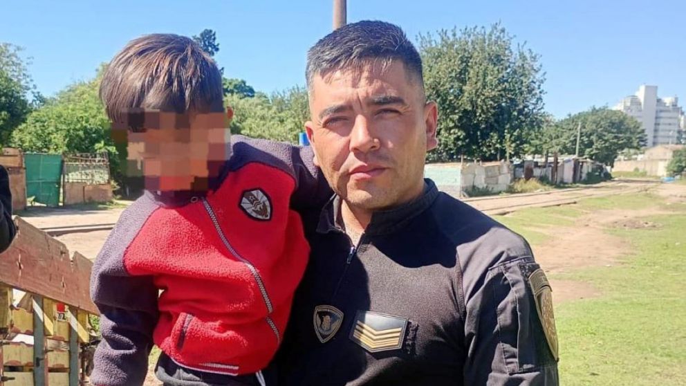 El polic�a junto al nene de tres a�os que logr� rescatar.
