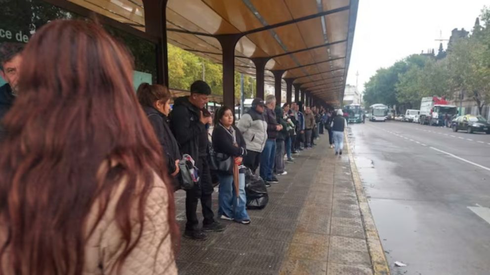 Pasajeros realizan largas filas frente a paradas de colectivos producto de la reducción de servicios.