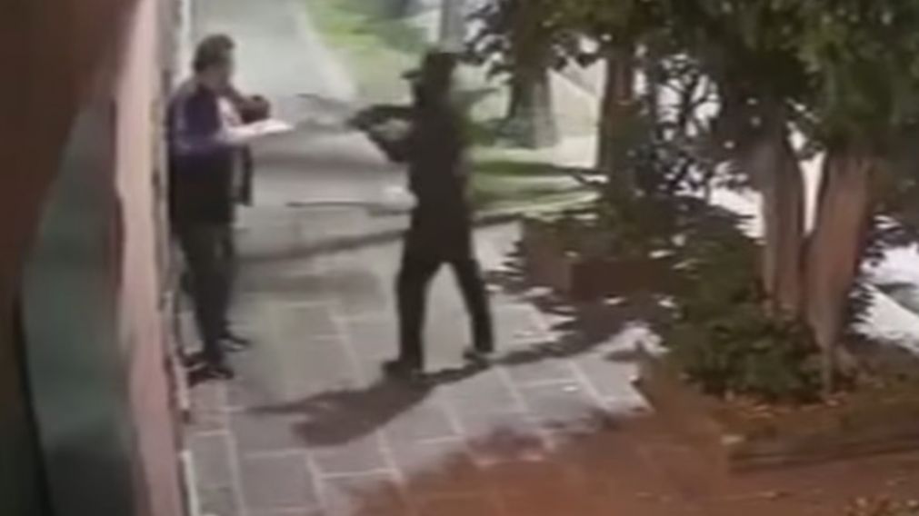 Impactante imagen del delincuente disparando a un repartidor de pizza (Captura de video).